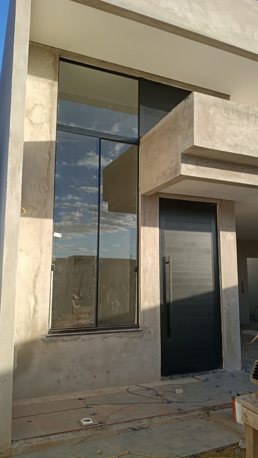 Painel de vidro piso-teto e porta em obra residencial